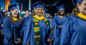Young woman in cap and gown at commencement ceremony.