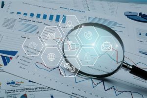 Magnifying glass hovering over balance sheets.