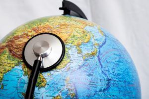 Stethoscope is resting on a globe of the world.