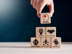 Building blocks with words like collaboration, decision making, and more are stacked on top of one another. A building block that says emotional intelligence is at the very top.