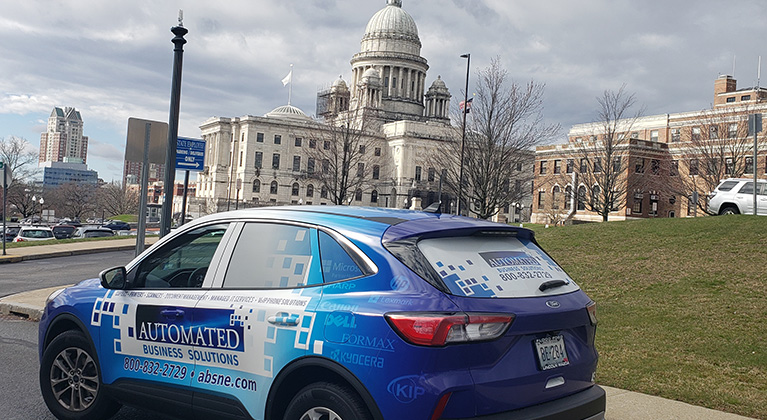 Image of an SUV with Automated Business Solutions car wrap in front of the Providence State House