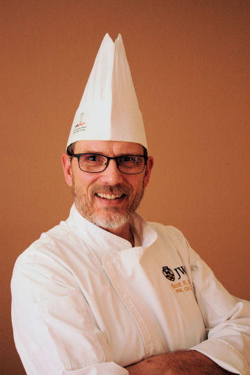 Headshot of Director of Online Culinary Programs, Scott Smith, in JWU chef uniform with a tall white chef cap.