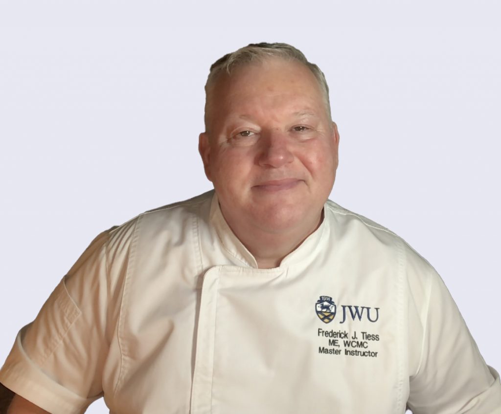 Headshot of Master Instructor, Fred Tiess, wearing a chef uniform with JWU logo and name.