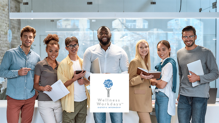 A multicultural group of young professional holding books, pens, and paper smiling at the camera