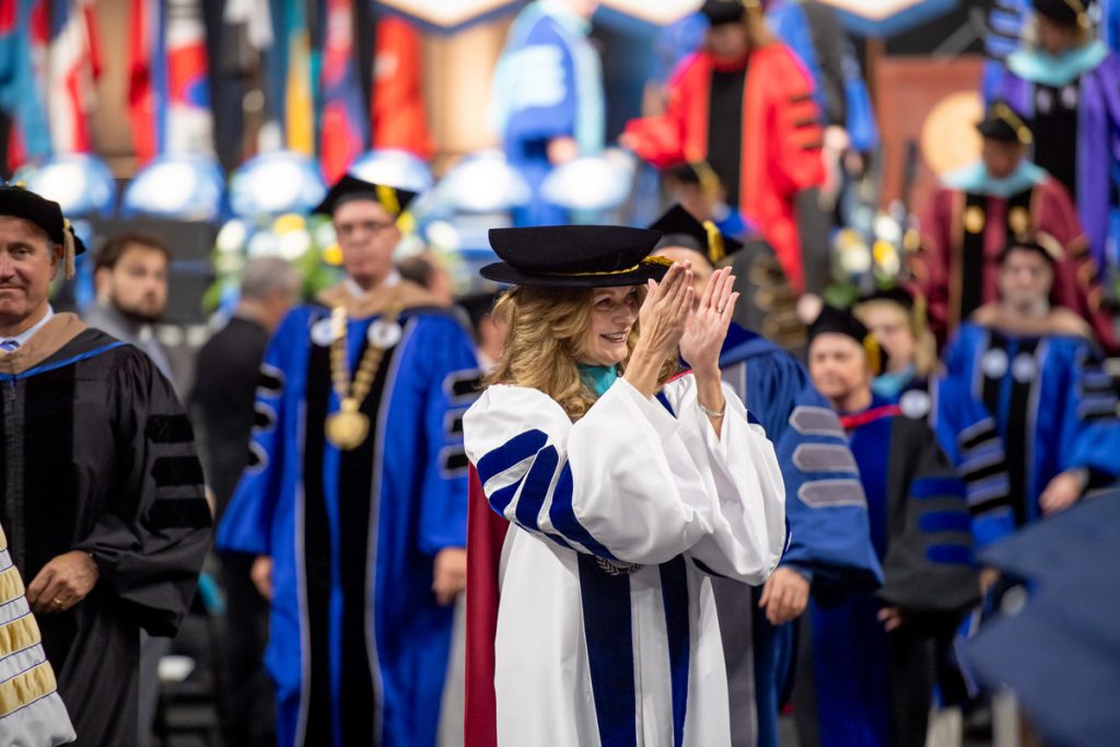 Johnson & Wales President, Marie Bernardo-Sousa smiles and claps as she leads the procession at the commencement ceremony.