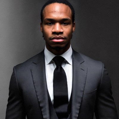 Portrait of Brandon Logan in a suit and tie.