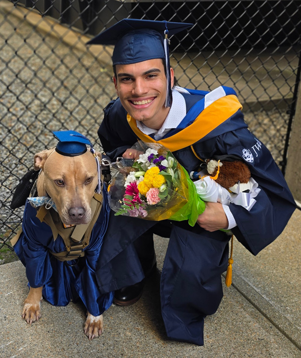 Dasan Orlich in his cap and gown with his dog, Dunkin, dressed in a cap and gown.