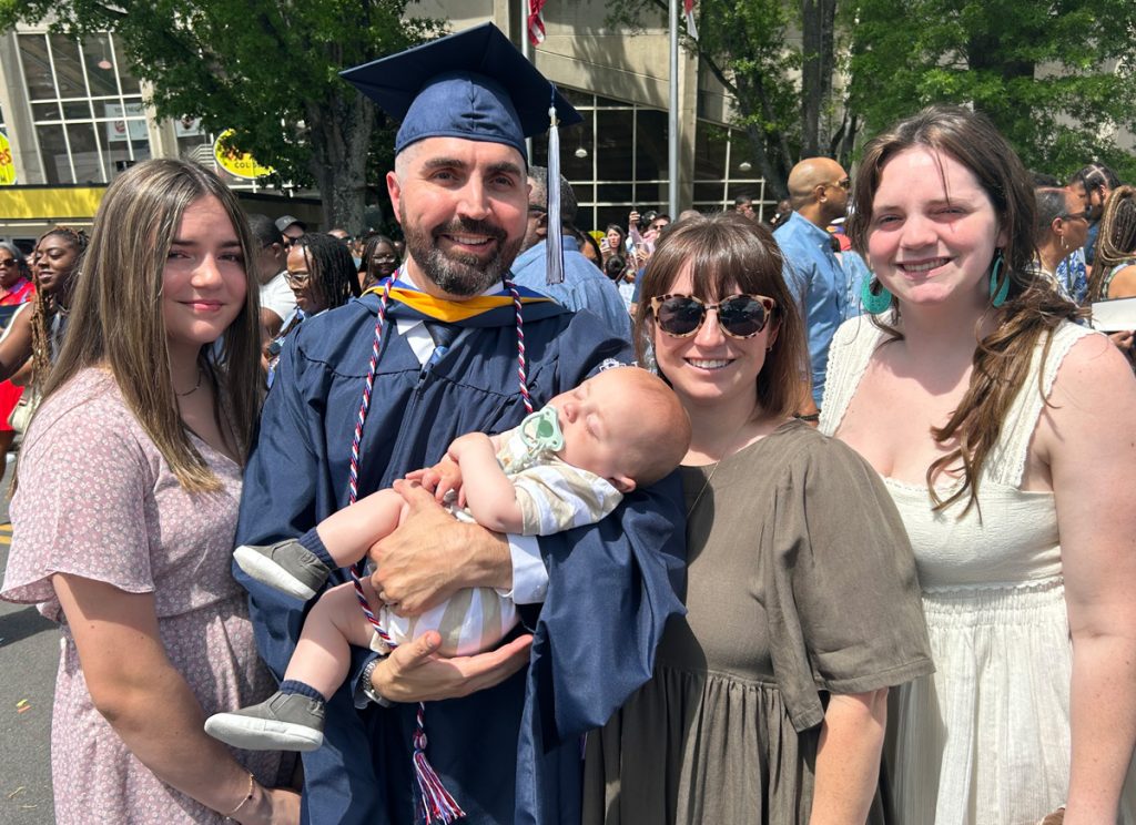 Jonathan Garrigues' family photo with two grown daughters, his wife and his baby son.