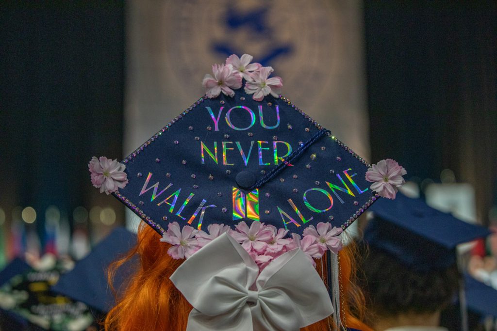 A decorated graduation cap with flowers, a bow and the words, "you never walk alone," at the 2025 Johnson & Wales Commencement Ceremony in Providence.