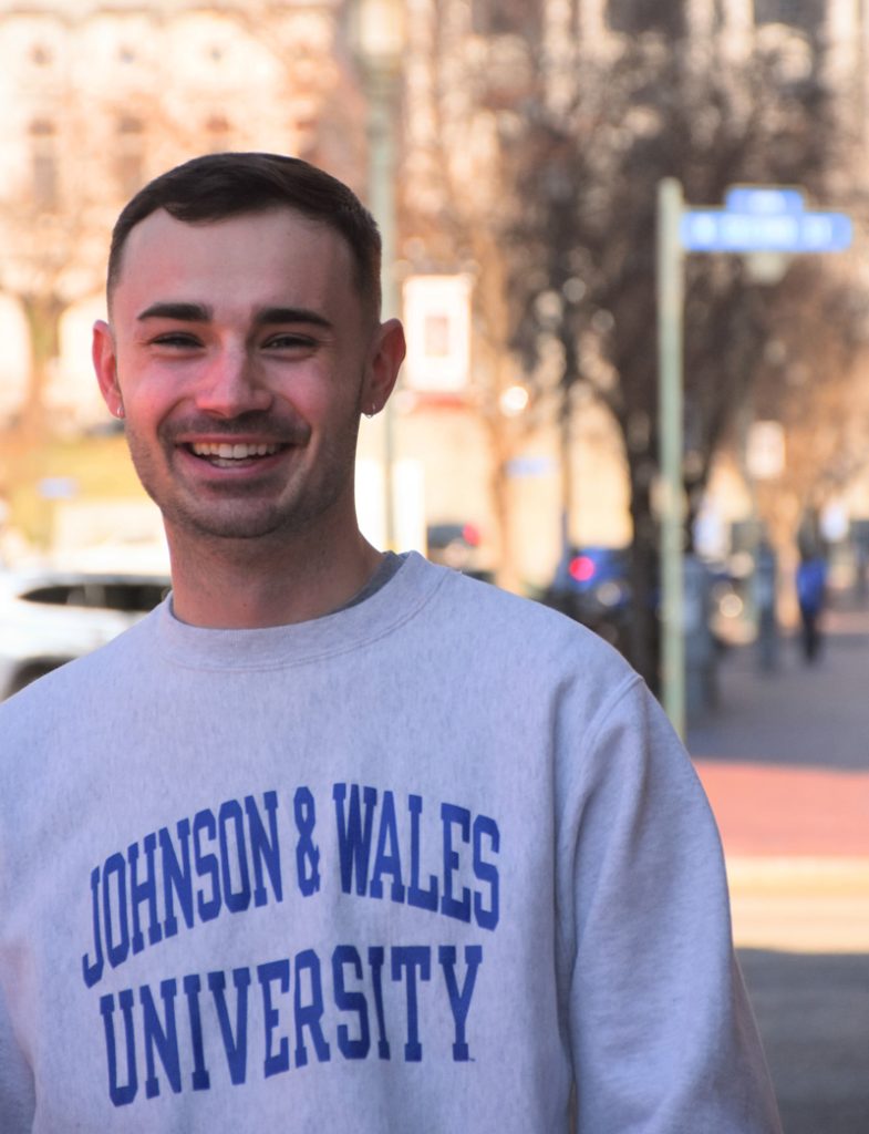 Young man, Ben, wearing a Johnson & Wales University sweatshirt while walking in Harrisburg, Pennsylvania.