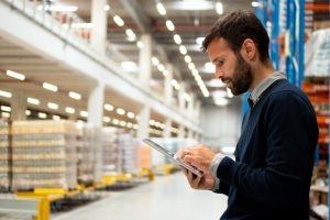 Purchasing manager holding digital tablet in warehouse