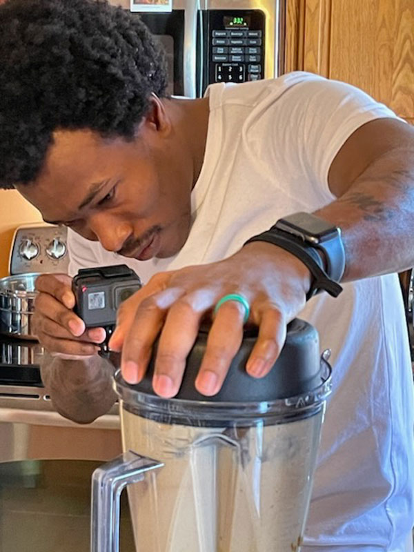 Markeith in his home kitchen making a nutritional drink in a blender.