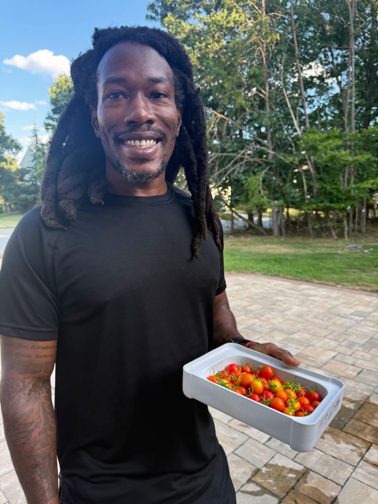 Markeith holding a box of cherry tomatoes he grew in his garden.