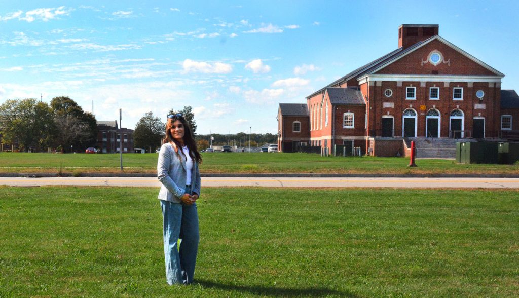 Reyna stands outdoors in the common area of the complex in which the Office of Healthy Aging is located.