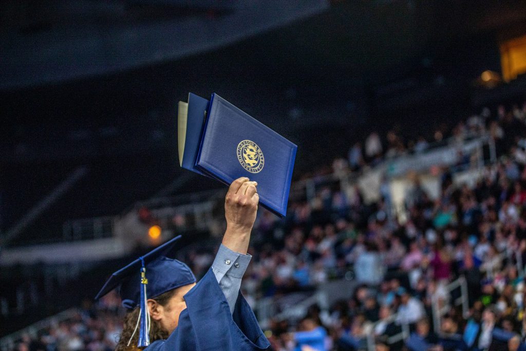 JWU graduate holding diploma