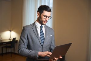 hotel manager in suit holding laptop computer