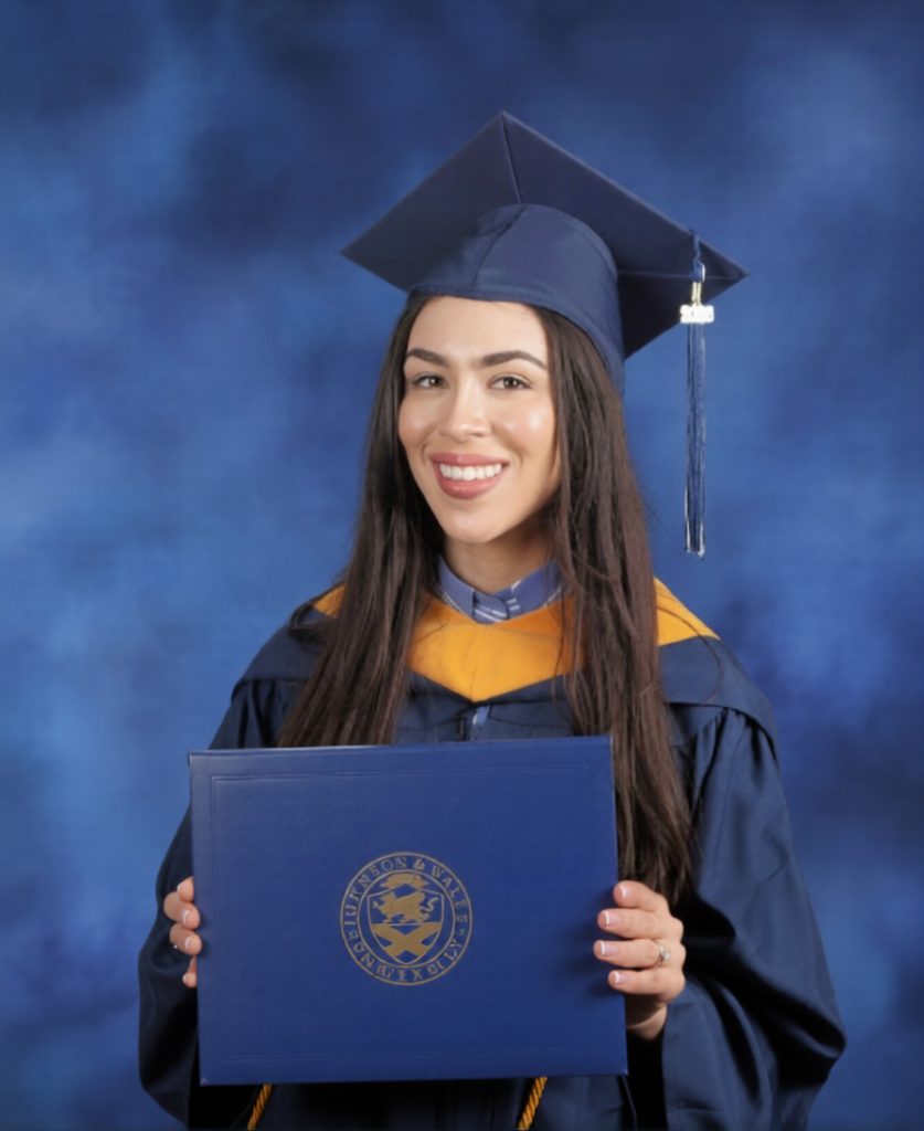 Portrait of Shyanne Cabreras in her cap and gown, holding her diploma.