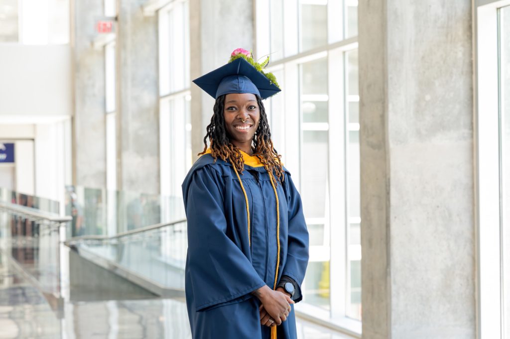 Direka Gordon in her cap and gown in front of windows at the Johnson & Wales Commencement ceremony in Charlotte, North Carolina.
