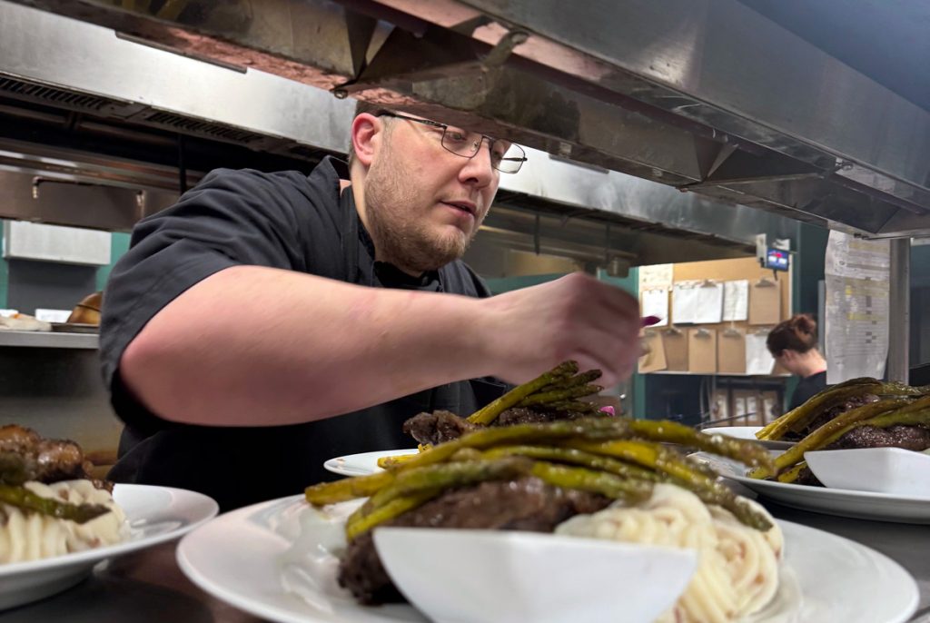 Executive Chef Michael Yates preparing a dish in the kitchen.